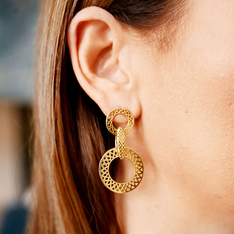 A woman wearing gold hoop earrings.