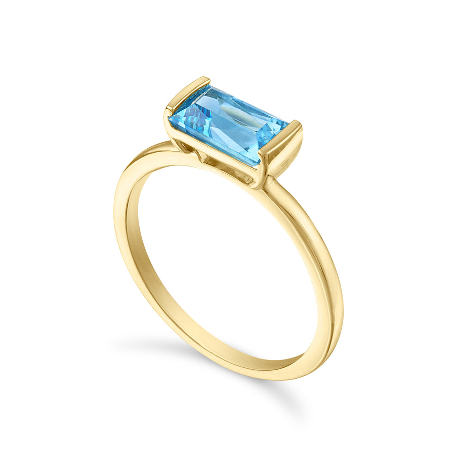 Side view of a blue topaz ring set in 14K yellow gold.