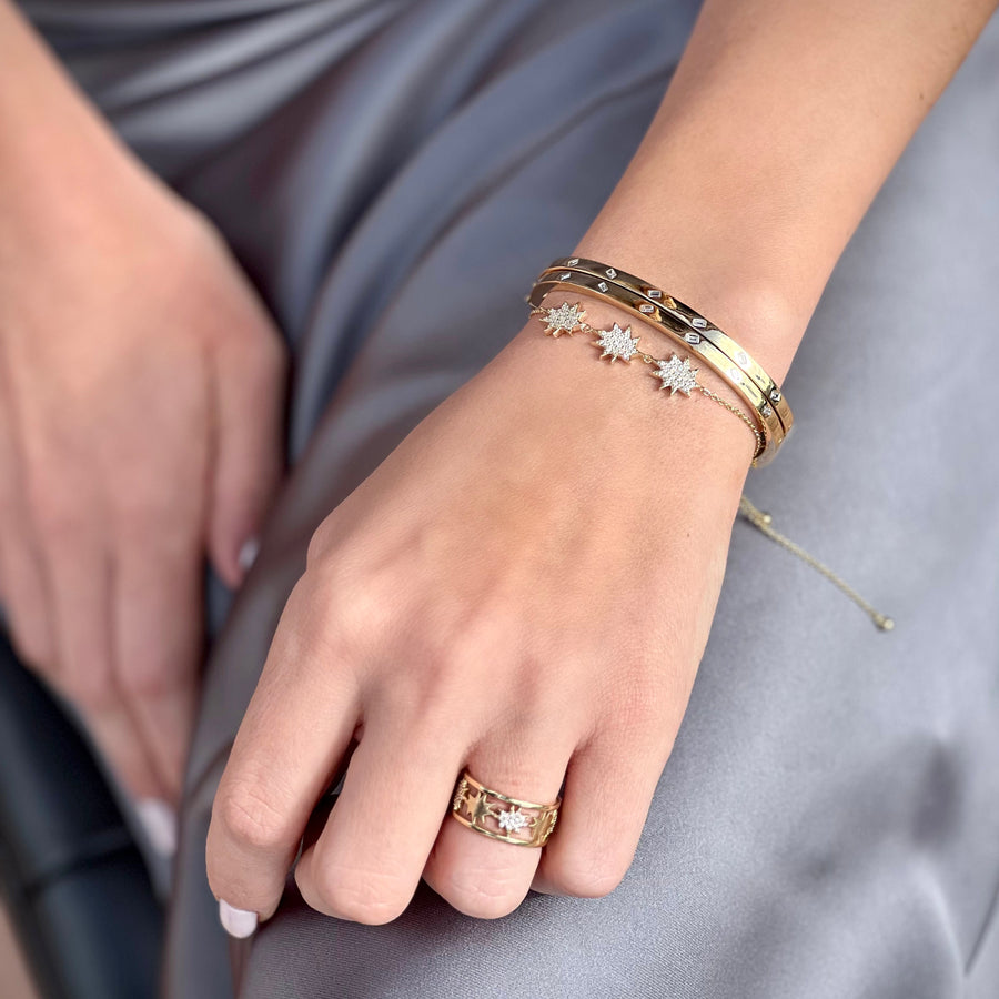 Two gold diamond bangle bracelets stacked on a wrist.