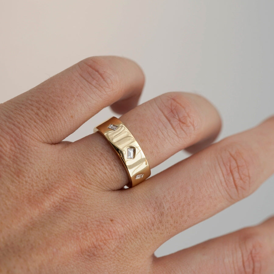 cigar band ring in 14K yellow gold on ring finger.
