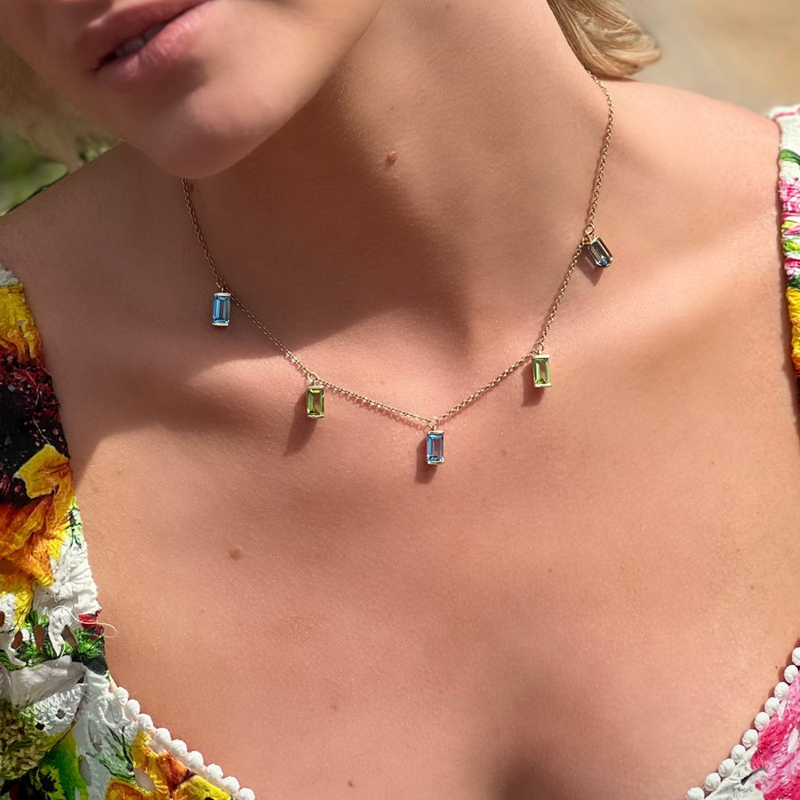 14K yellow gold peridot and blue topaz statement necklace worn by model.